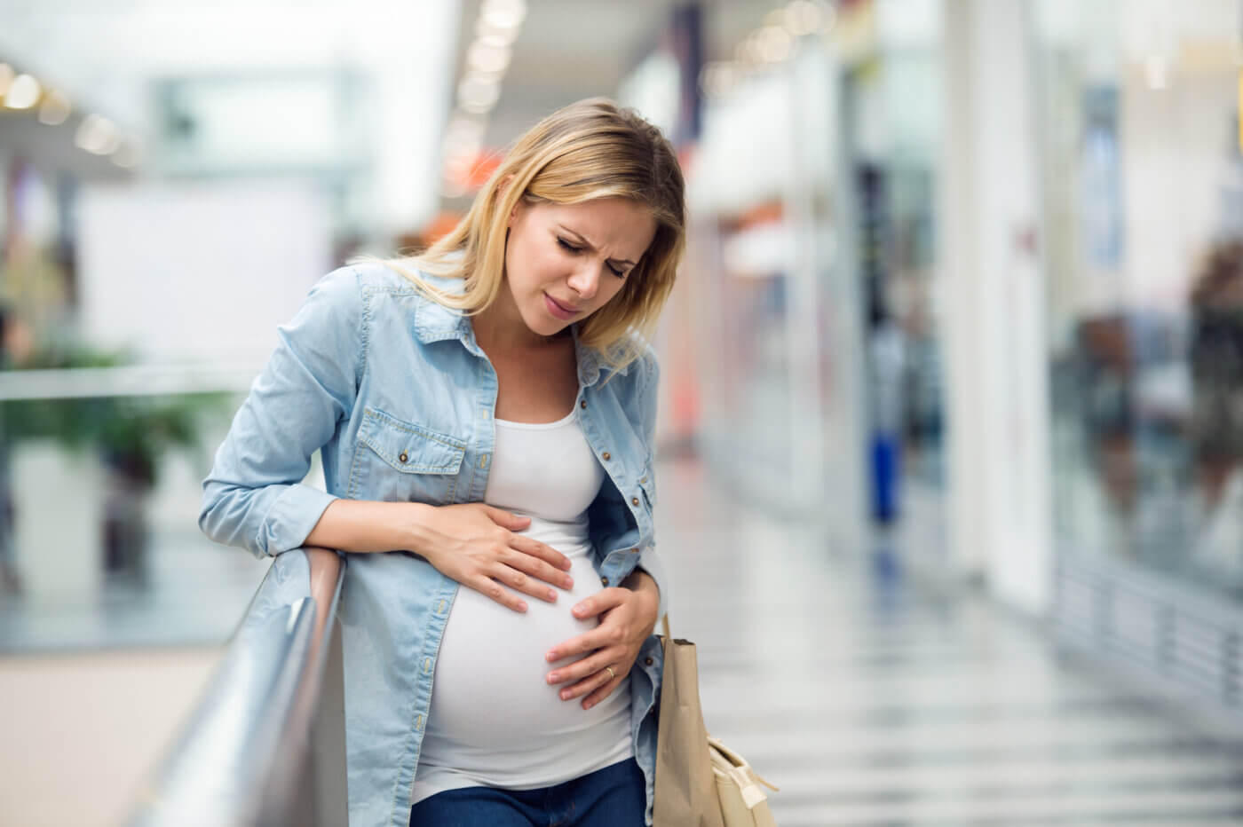 Pregnant woman touching her belly, having pains Belly Side Pain during Pregnancy - Round ligament strain